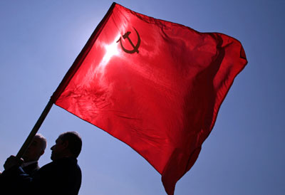 Bulgarian men wave a red Soviet flag in front of the Monument of the Red Army in central Sofia May 9, 2007. Several hundred Bulgarians gathered to celebrate the World War Two Victory Day on Wednesday.