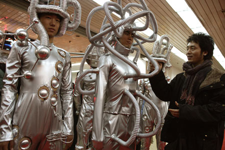 A visitor looks at models whose clothes were made out of environment-friendly materials at the first China Beijing International Cultural and Creative Industry Expo yesterday. The event, a visual, creative and ideological feast integrating culture, creativity and modern technology for the cultural and creative industrial circles both at home and abroad, aims to provide a platform for domestic and foreign investors to boost the development of the nation's creative industry.