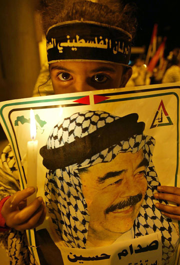 A Palestinian girl lights candles at a rally to protest the execution of former Iraqi President Saddam Hussein, in Rafah, south of Gaza strip December 30, 2006. Saddam was hanged at dawn on Saturday in Baghdad for crimes against humanity as Iraq's prime minister rushed through an execution that delighted victims of Saddam's harsh rule. 