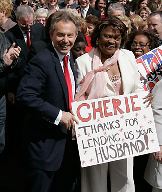 Britain's Prime Minister Tony Blair (L) laughs with supporters as he arrives at Trimdon Constituency Labour Club in Trimdon, northeast England May 10, 2007. 