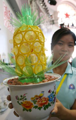 A worker shows a design made of condoms at the 4th China Reproductive Health New Technologies & Products Expo in Beijing July 11, 2007. Condoms of all shapes and sizes were on show at a Beijing fashion show on Wednesday featuring dresses, hats and even lollipops made of the said item.