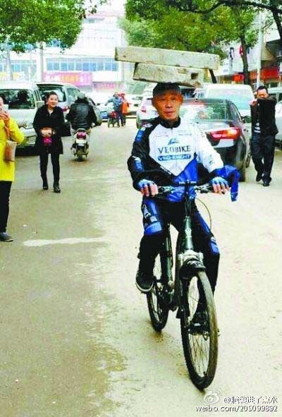 Man cycles with 34kg stone on head