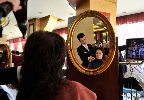 A child gets a haircut at a barbershop in Hefei